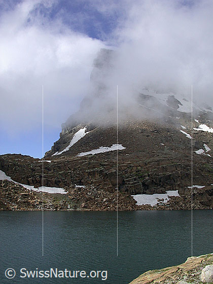 Foto: Geisspfadsee mit Geisspfad. Hinter Nebelschwaden ist das Rothorn erkennbar.