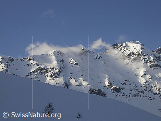 Foto: Blick vom Mässersee zum Schwarzhorn. Wolkenfetzen ziehen über die Flanke. Streiflicht am Schwarzhorn. Die Aufnahme entstand am frühen Morgen.
