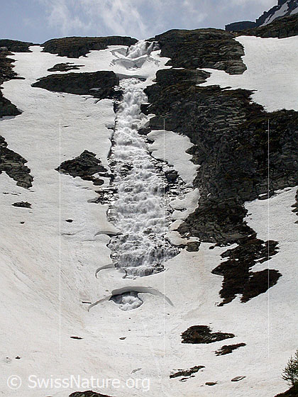Foto: Im Abstieg vom Geisspfad: Hoher Wasserfall des Mässerbach bei Zantmärjelebiel. Mit Schneebrücken über Wasserfall.