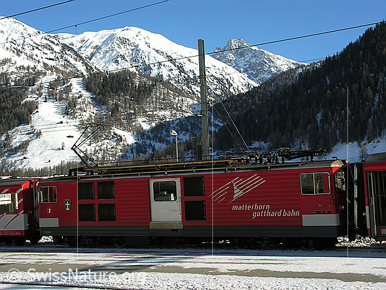 Foto: Matterhorn-Gotthard Bahn am Bahnhof Oberwald. Im Hintergrund der Einschnitt ins Geretal.