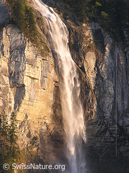 Foto: Wasserfall bei Unterbach im Abendlicht. Das Wasser stürzt über eine hohe Felswand.