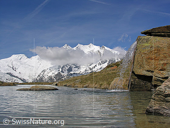 Foto: Alphubel und Mischabel (mit Wolke).
Davor ein Bergsee und ein kleiner Wasserfall.