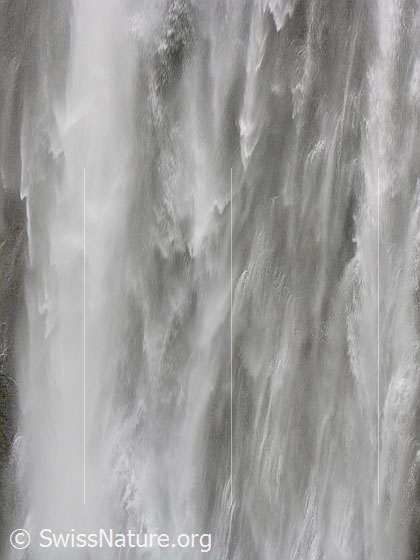 Foto: Grosser Wasserfall der Engstligenfälle. Das Wasser stürzt tosend über eine hohe Felswand (Ausschnitt).