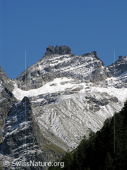 Foto: Gischihorn mit gezacktem Grat und leicht mit Schnee überzuckert. Felsbänder und Strukturen im Fels kommen schön zum Vorschein.
