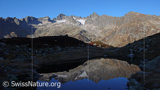 Foto: Spiegelbild einer Bergkette. Die Fünffingerstöck spiegeln sich im stillen Wasser.