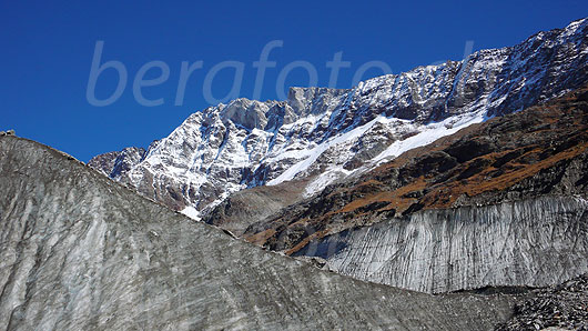 Foto: Bergwelt mit Eiswänden am Langgletscher. Das Schinhorn ist bereits leicht verschneit und die Grasbänder über dem Gletscher sind herbstlich gefärbt.