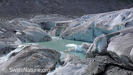Foto: Gletschersee an Rhonequelle. Gletscherzunge und Gletschertor des Rhonegletschers münden in einen neu entstandenen Gletschersee. Der Gletscher hat auf seinem Rückzug einen Felsriegel freigelegt, an welchem sich das Wasser nun staut. Durch weiteres Abschmelzen des Gletschers wird sich der See vergrössern und könnte im Laufe der Zeit eine Naturgefahr darstellen.

