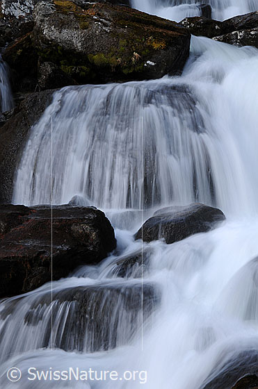 Foto: Wasserfall in Bergbach. Das Wasser fällt über verschieden hohe Felsstufen talwärts.