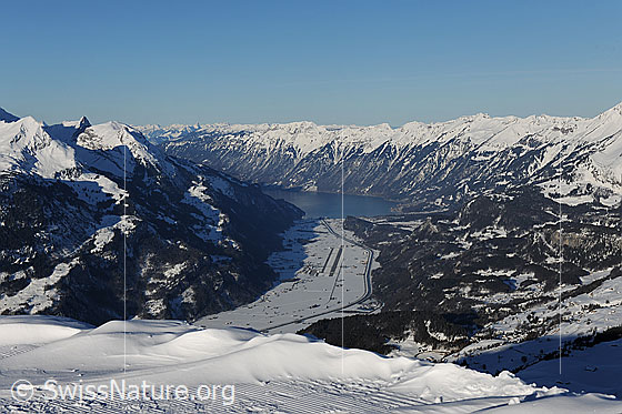 Foto: Haslital und Brienzersee.
Tiefblick auf die Ebene zwischen Meiringen und dem Beginn des Brienzersees. Links im Bild sind die verschneiten Voralpengipfel Wandelhorn, Axalphorn, Oltschiburg und im Hintergrund der Brienzer Grat zu sehen.