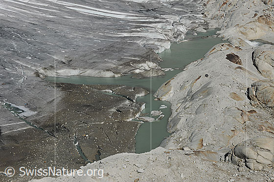 Foto: Rhonegletscher: Gletschereis und Gletschersee an der Gletscherzunge des Rhonegletschers. Durch die Gletscherschmelze ist die Eisschicht dünn geworden und der See vergrössert sich zusehends. Ein Felsriegel mit Gletscherschliff verhindert das Auslaufen des Sees. Rechts oben im Bild ist der Ausfluss zu sehen.
