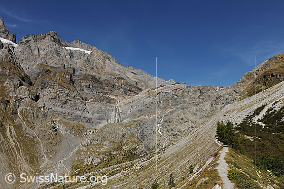 Foto: Hinterer Teil des Gasteretals mit steil abfallenden Hängen und Felswänden. Der Hüttenweg Richtung Mutthornhütte führte hier über die leicht bewachsene Seitenmoräne.
