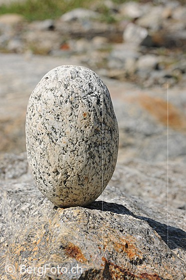 Foto: Steinmann als ovaler Stein auf Fels.