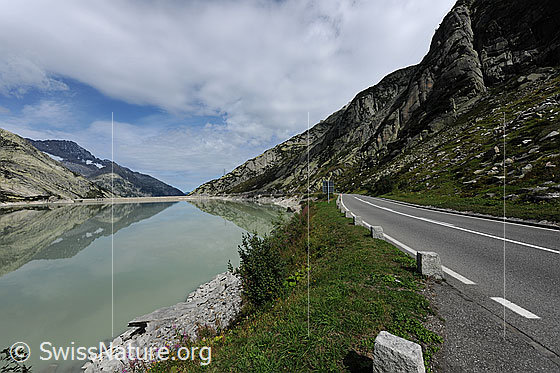 Foto: Stausee und Passstrasse. Räterichsbodensee an der Grimselpassstrasse mit Blick zum Ritzlihorn und auf die Spiegelung im See.