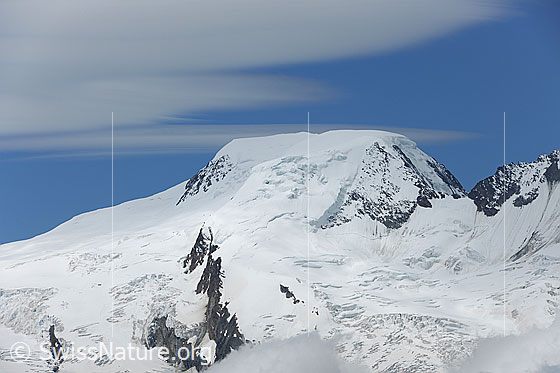 Foto: Alphubel.
Portrait des Viertausenders mit Wolkenfeld am blauen Himmel.