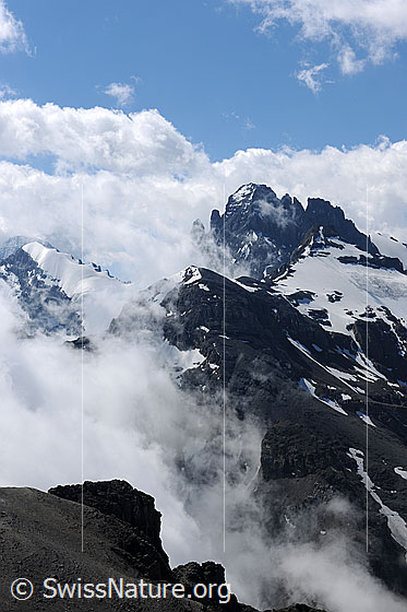 Foto: Stimmungsbild: Wolken und Berggipfel. Dichtere Quellbewölkung zieht sich um die Gipfel von Tschingelspitz und Gspaltenhorn. Vorgelagert sind Vorderi Bütlasse, Bütlasse und Bütlassegletscher zu sehen.