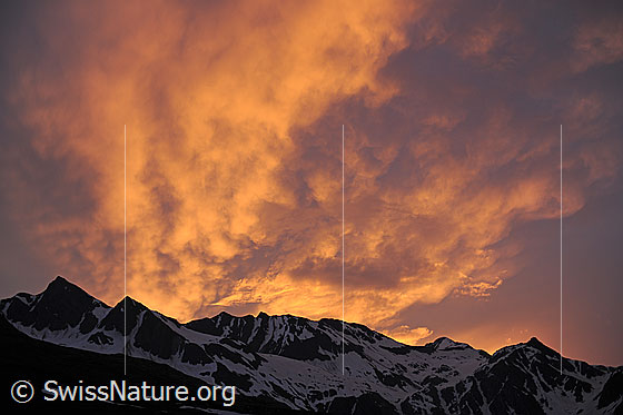 Foto: Morgenstimmung mit brennenden Wolken über einer Bergkette. Morgendliches Spektakel über Turbhorn und Strahlgrät..