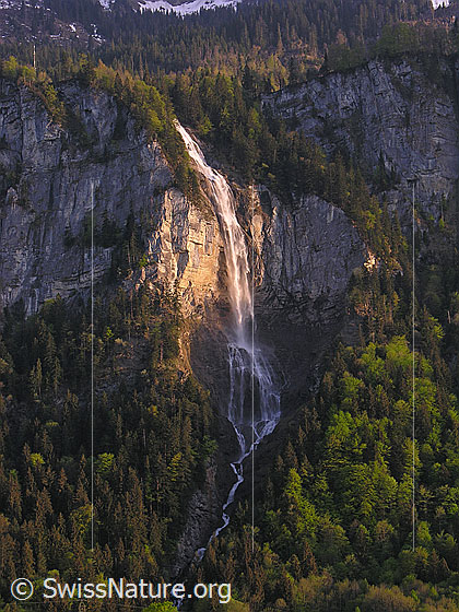 Foto: Wasserfall bei Unterbach im Abendlicht. Das Wasser stürzt über eine hohe Felswand.